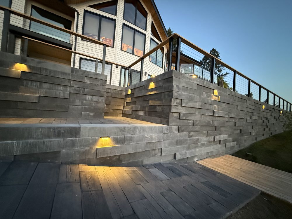 Retaining wall with integrated step lighting at dusk, KDT Landscaping Kelowna